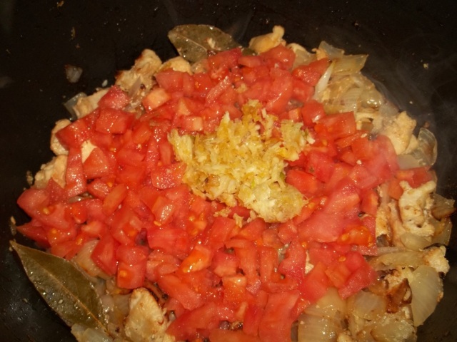 Adding Tomatoes and Garlic to Onions and Chicken